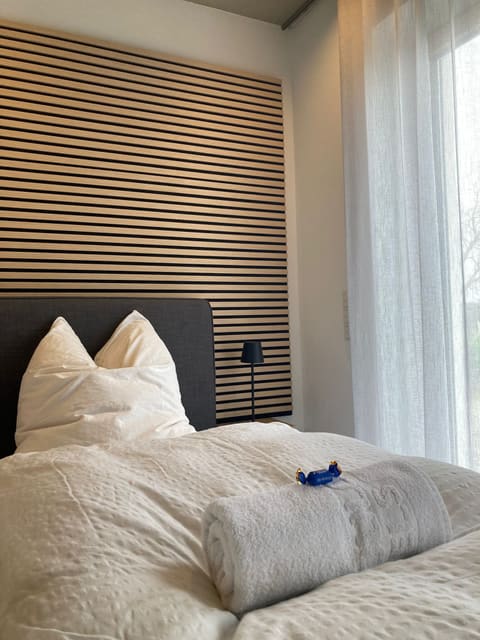 Frisch bezogenes Bett mit Handtüchern am Fenster