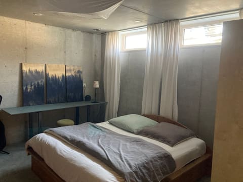 Doppelbett unter Fensterbändern mit Waldbild